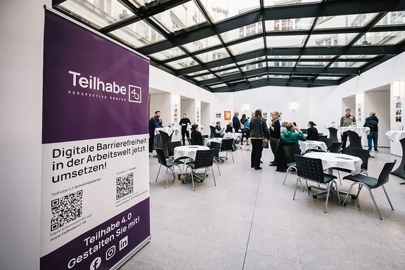 Fachtagung Teilhabe 4.0 Eingangsbereich der Fachtagung im Februar 2024 mit einem Aufsteller des Projekts im Vordergrund.